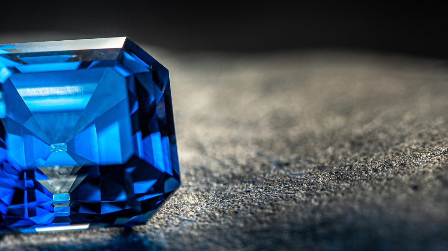 Blauer Edelstein liegt auf grauem Stein