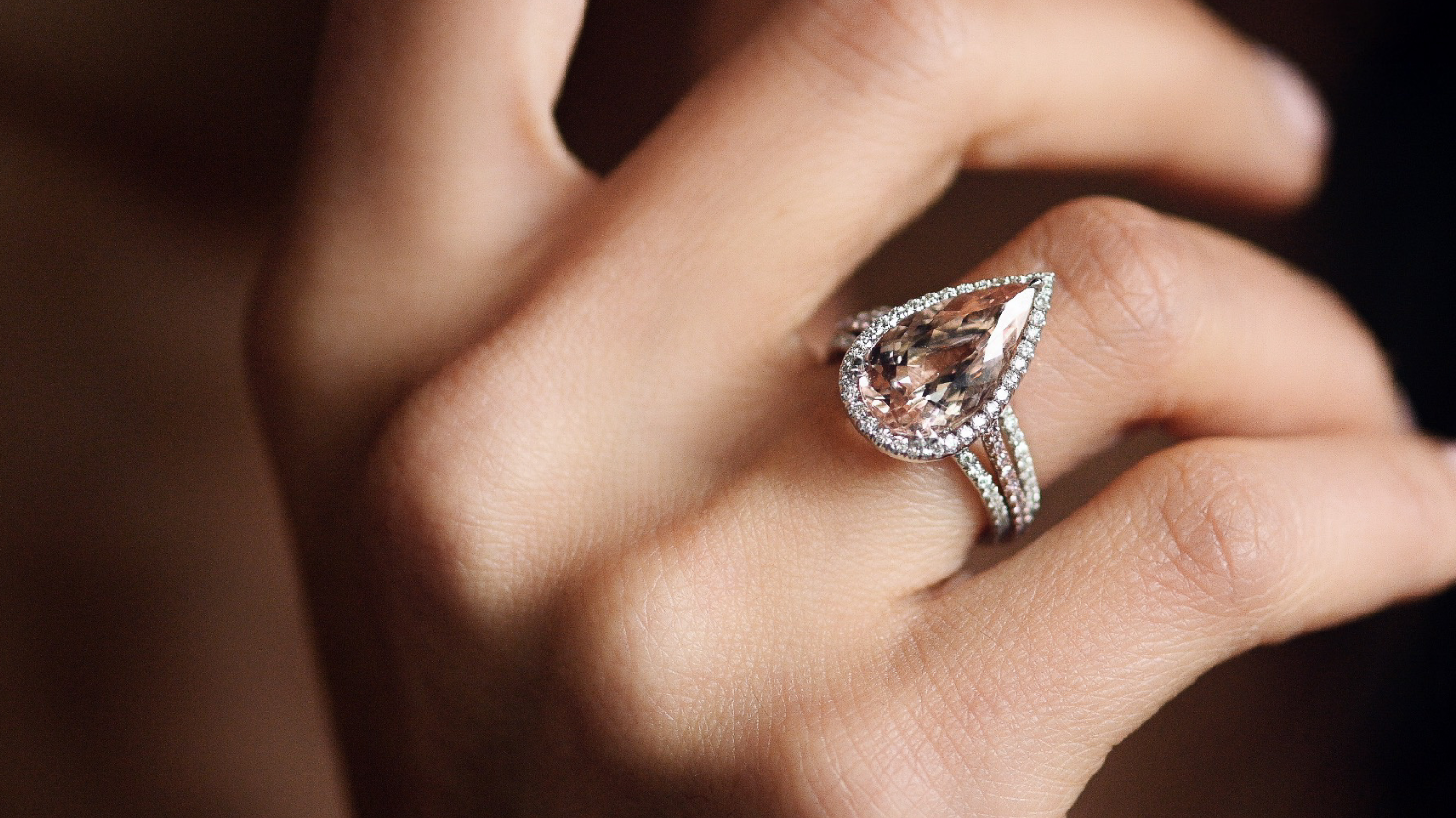 Diamantring im Tropfenschliff und Brillanten an der Hand einer Frau