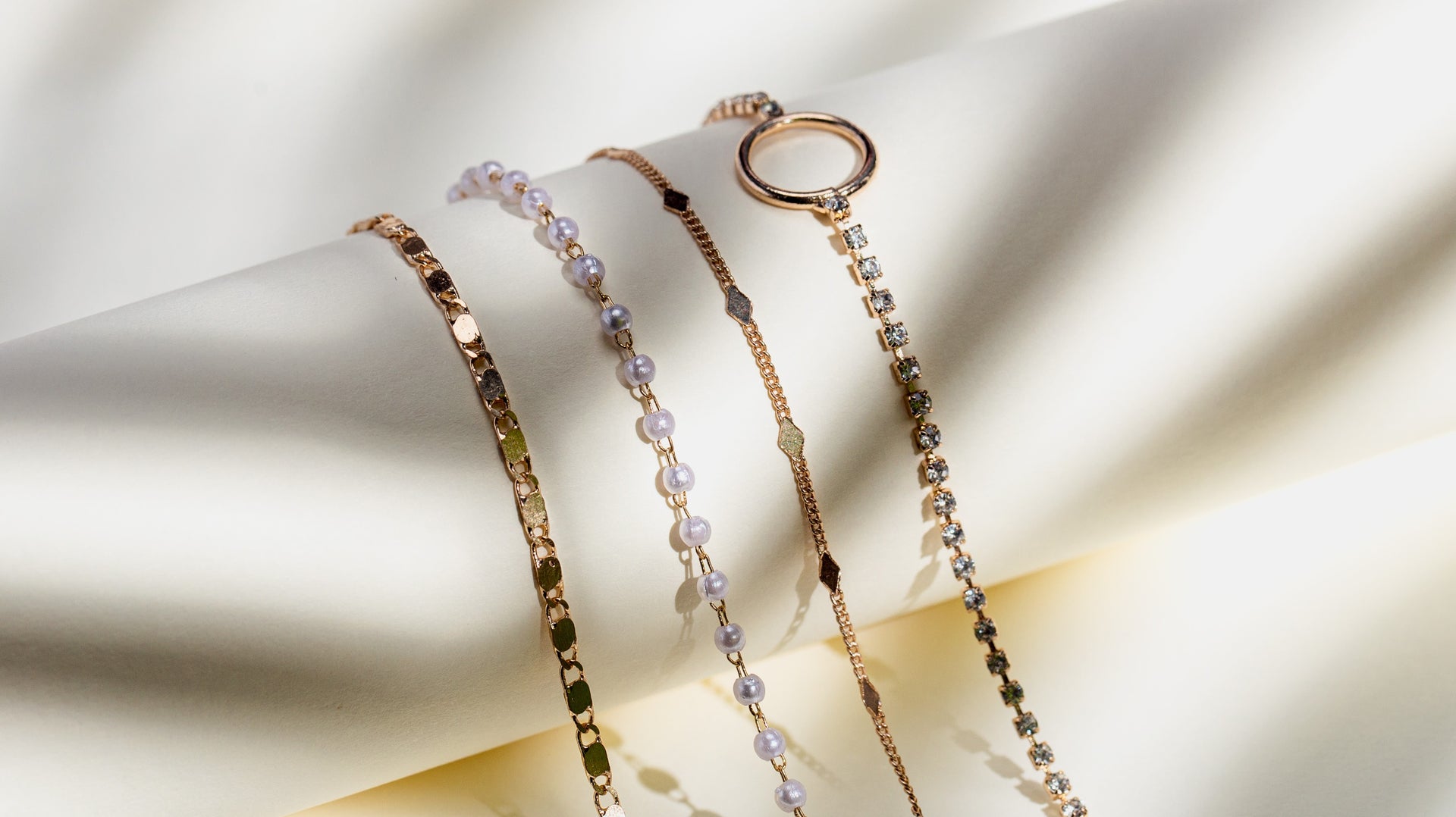 Goldarmbnder mit Perlen und Glitzersteinen