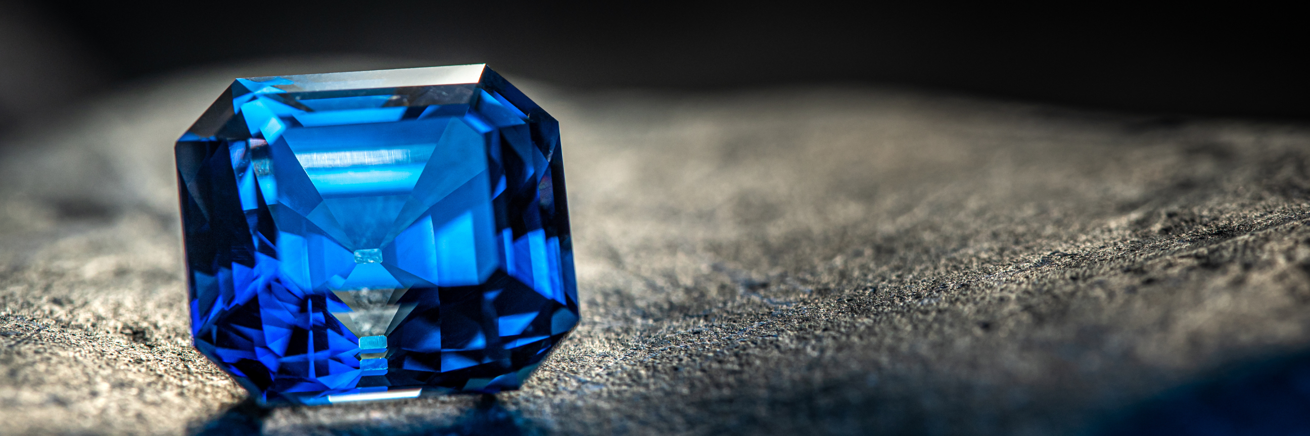 Blauer Edelstein liegt auf grauem Stein