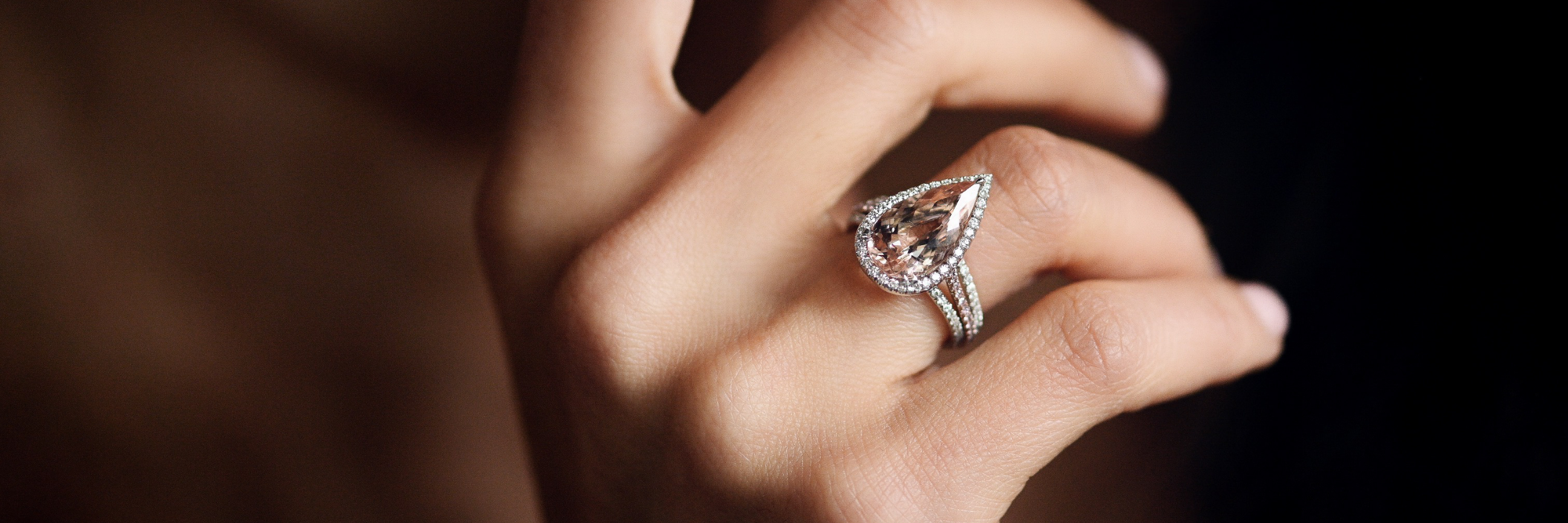 Diamantring im Tropfenschliff und Brillanten an der Hand einer Frau